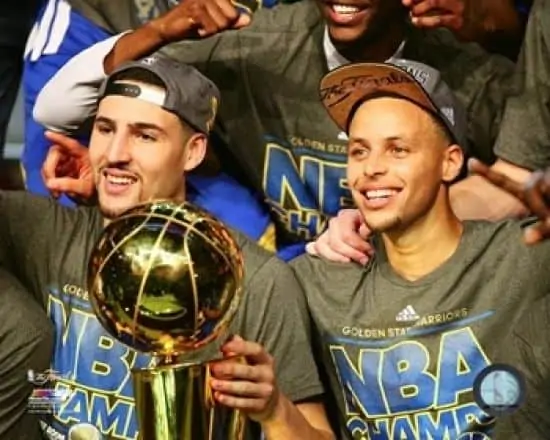 Klay Thompson with Stephen Curry and the NBA Championship trophy.